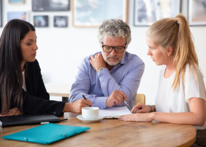 Family legal advisor explaining document details to mature father and adult child.