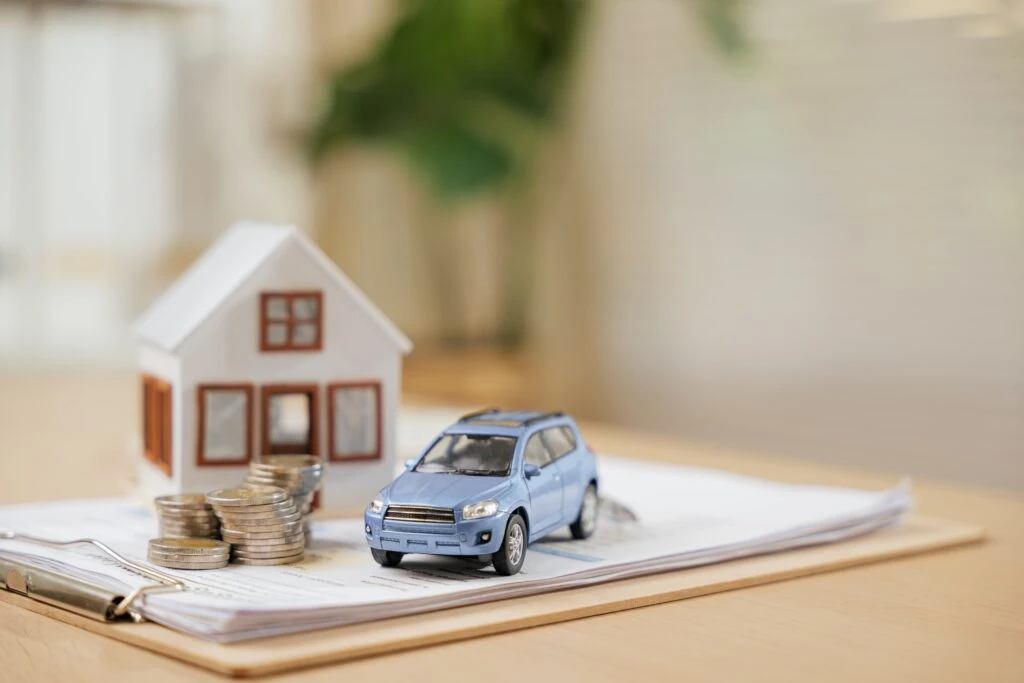 Estate planning services represented by image of home, car, and money on a stack of documents.