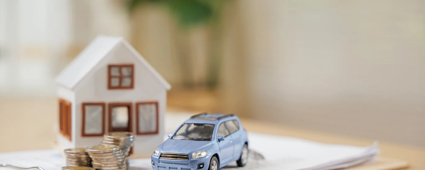 Estate planning services represented by image of home, car, and money on a stack of documents.